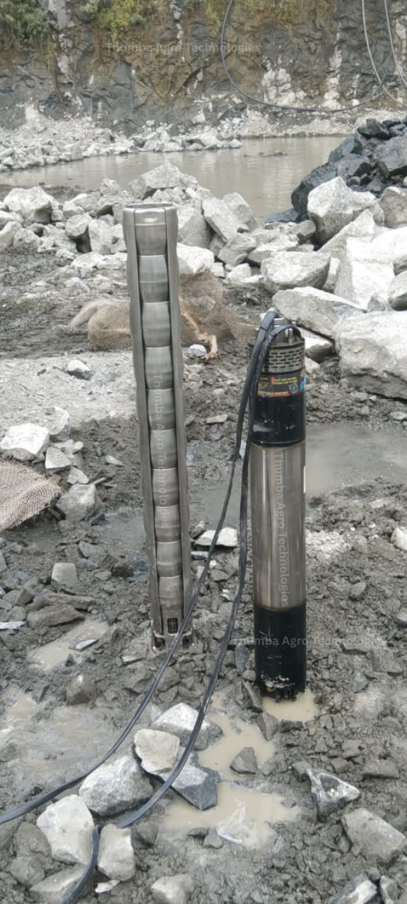 Thumba 20 HP quarry pumpset shown in two parts on the quarry floor — the multistage stainless steel pump section and the motor section with cabling
